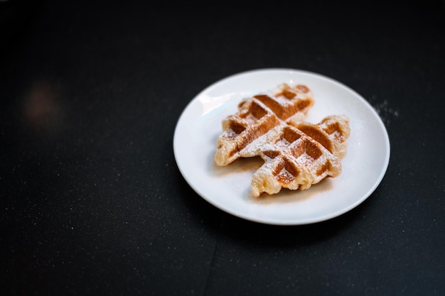 Croffle è una combinazione di croissant e waffle Questo croffle servito su un piatto bianco