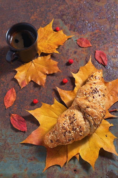 Croissant al caffè e foglie autunnali