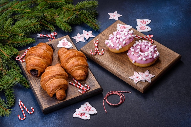 Croissant al cioccolato croccante con decorazioni natalizie su tagliere di legno