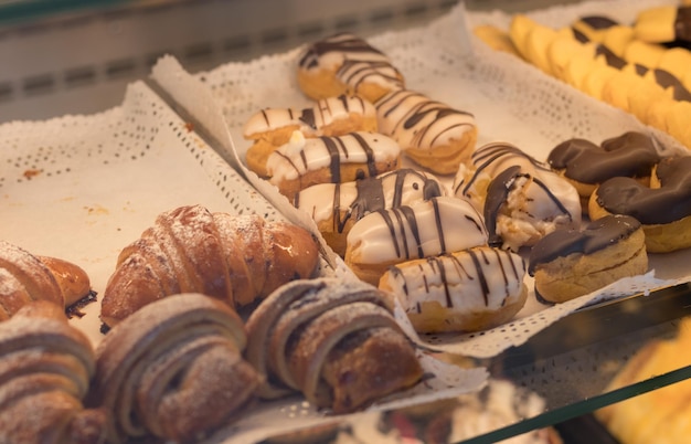 Croissant al cioccolato e altri dolci sul bancone della pasticceria Pasticceria fresca Dessert dolci vendita di dolciumi