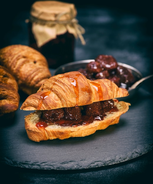 Croissant al forno con marmellata di fragole sul nero