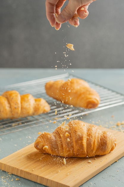 Croissant appena sfornati sul piatto di legno.