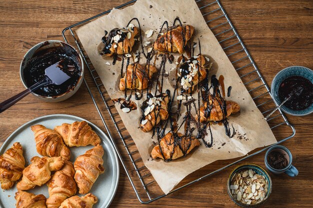 Croissant con cioccolato e spruzza su un tavolo di legno.