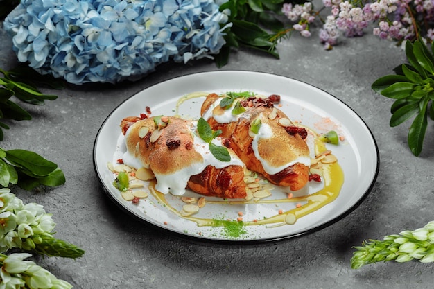 Croissant con crema dolce e mandorle su un piatto Colazione deliziosa e sana