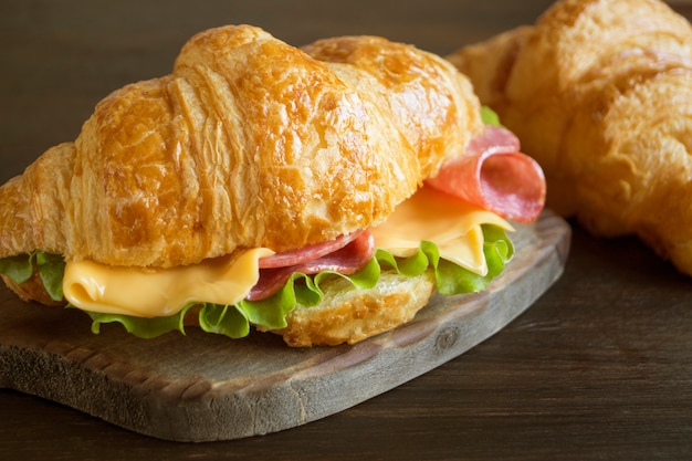 Croissant con formaggio e erbe salsiccia. su sfondo scuro