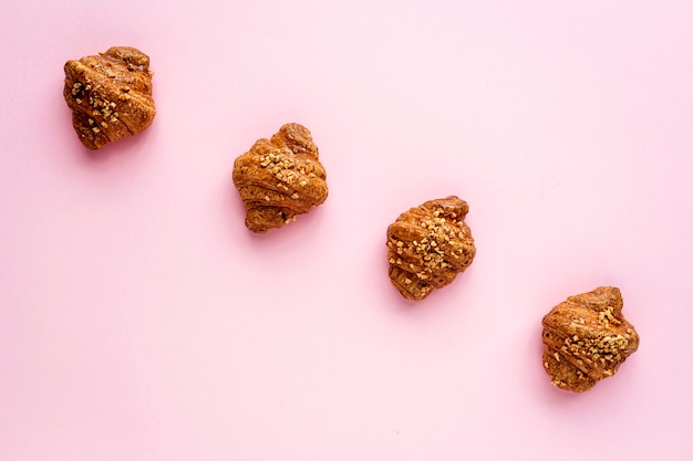 Croissant con mandorle su sfondo rosa