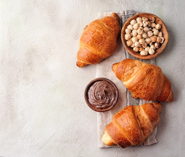 Croissant con pasta al cioccolato e nocciole su tavoli di cemento.