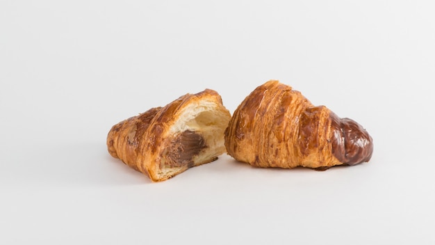 Croissant con ripieno di cioccolato isolato su sfondo bianco