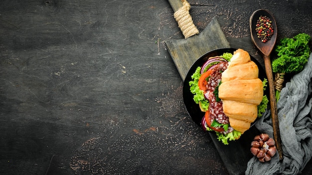 Croissant con salame, pomodori e cipolle Colazione Vista dall'alto Spazio libero per il testo