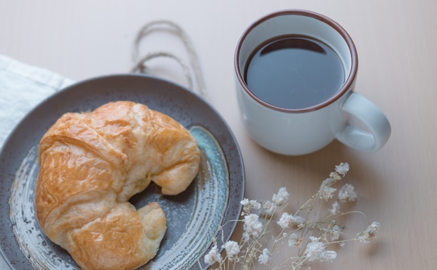 Croissant con una tazza di caffè nero