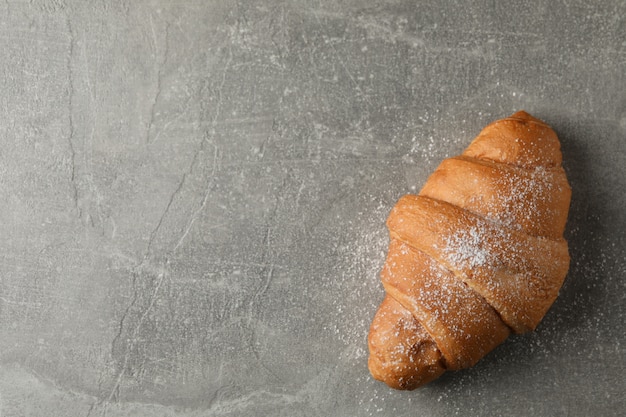 Croissant con zucchero a velo su sfondo grigio, vista dall'alto