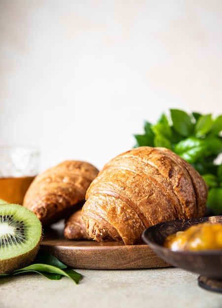 Croissant croccante con succo di marmellata di arance e kiwi per colazione Colazione gustosa