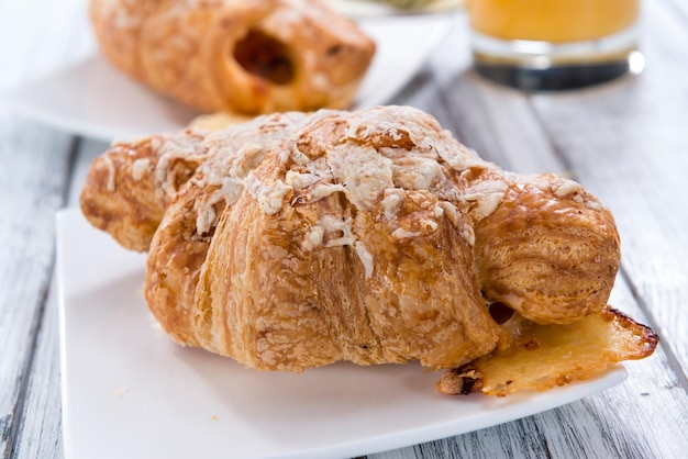 Croissant di prosciutto e formaggio su un vecchio tavolo di legno