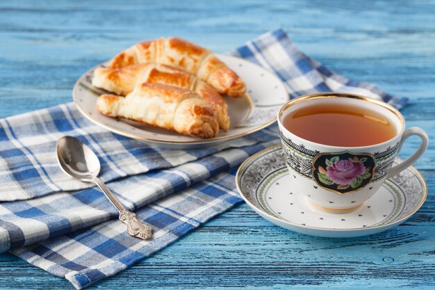 Croissant e tè in tazza. Concetto di colazione