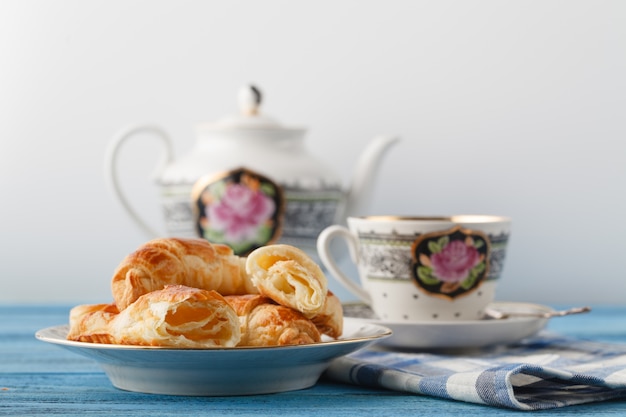 Croissant e tè in tazza. Concetto di colazione