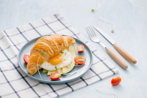 croissant farcito con avocado, uovo di frittata e verdura fresca