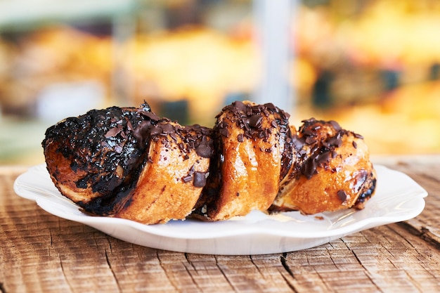 Croissant francese al cioccolato su un piatto bianco. Rotoli di pasta sfoglia sfornati in casa