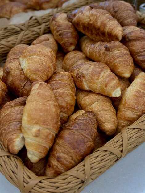 Croissant francesi freschi in un cestino vista dall'alto Dolci per la colazione Croissant in primo piano