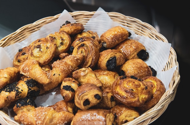 Croissant francesi sul cesto di vimini, sfondo di panetteria