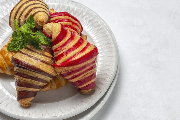 Croissant francesi tradizionali fatti in casa alla fragola, al cioccolato e alla vaniglia appena sfornati