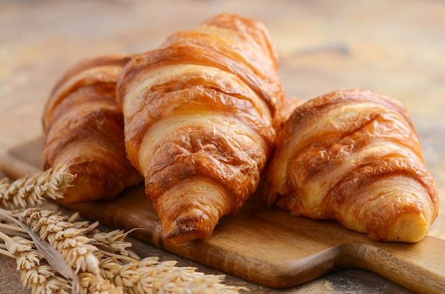 Croissant freschi su un fuoco selettivo del tagliere di legno