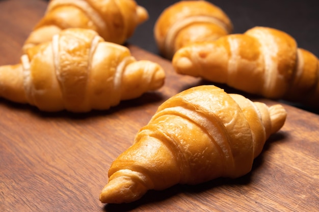 Croissant freschi su una tavola di legno Croissant da forno fresco fuoco selettivo