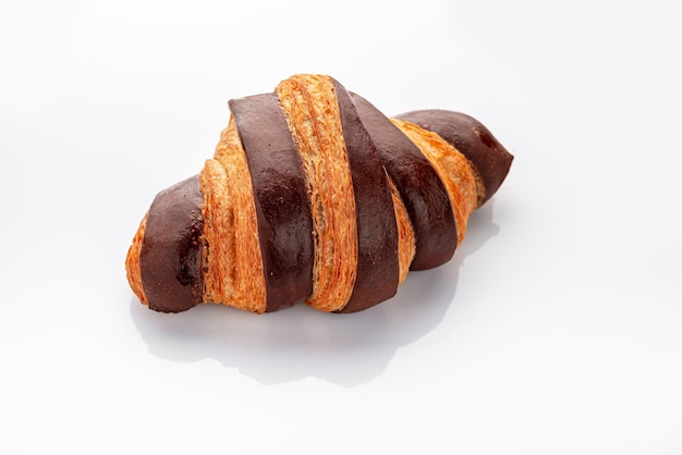 Croissant fresco con cioccolato su sfondo bianco