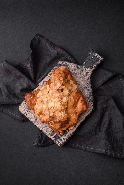 Croissant fresco croccante con scaglie di mandorle e ripieno di cioccolato