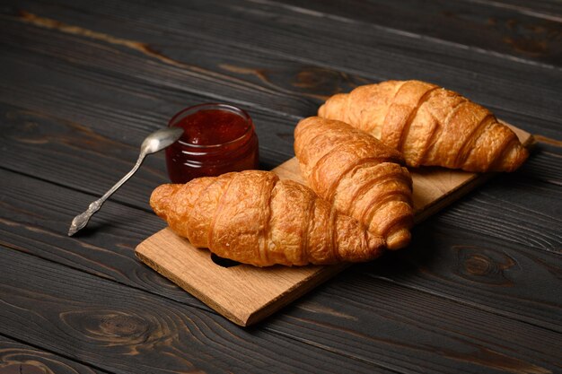 Croissant gustosi e deliziosi con marmellata su un tavolo di legno