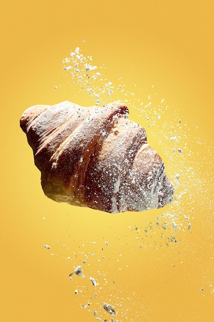 Croissant in levitazione con farina o zucchero a velo. Croissant appena sfornato per colazione con pa