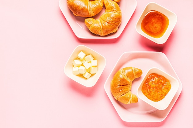 Croissant per colazione su uno sfondo rosa, vista dall'alto,