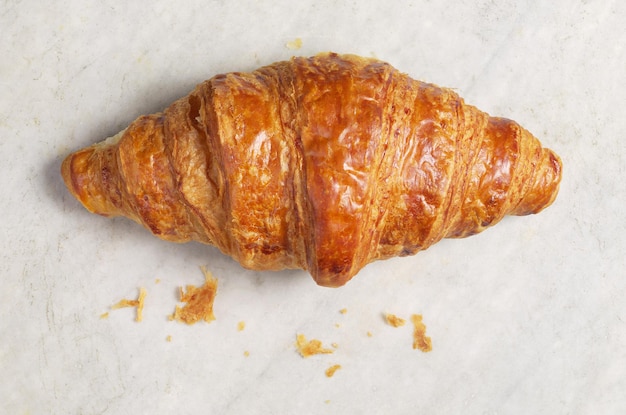 Croissant su uno sfondo di marmo bianco vicino alla vista dall'alto