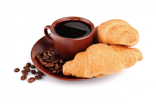 Croissant, tazza di caffè e fagioli isolati su bianco