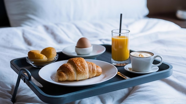 Croissant uova bollite succo d'arancia yogurt colazione su vassoio a letto in camera d'albergo