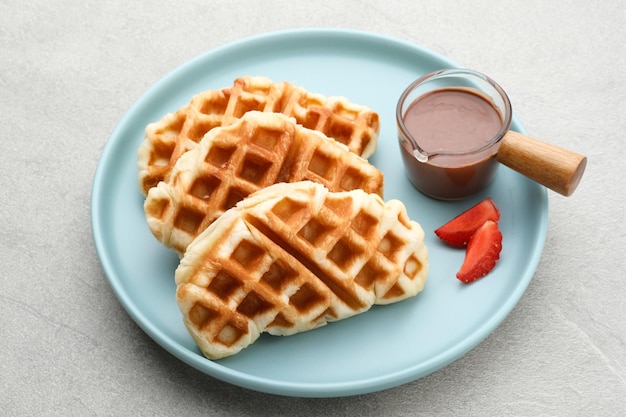 Croissant Waffle Croffle con topping al cioccolato e fragole servito nel piatto Close up