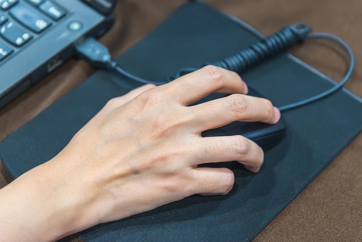 Photo cropped hand using computer mouse on table