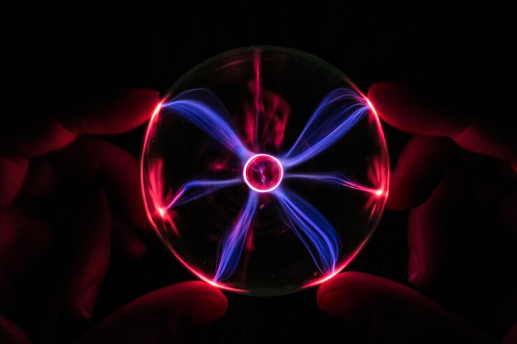 Photo cropped hands of person holding illuminated crystal ball against black background