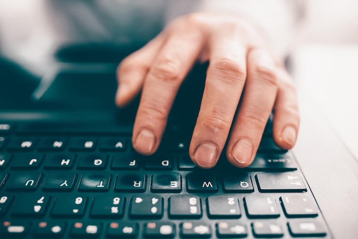 Photo cropped hands typing on keyboard