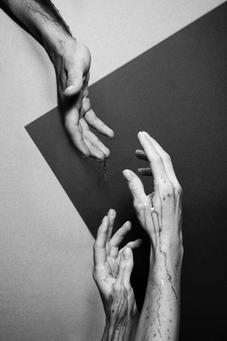 Photo cropped image of hands reaching towards each other against wall