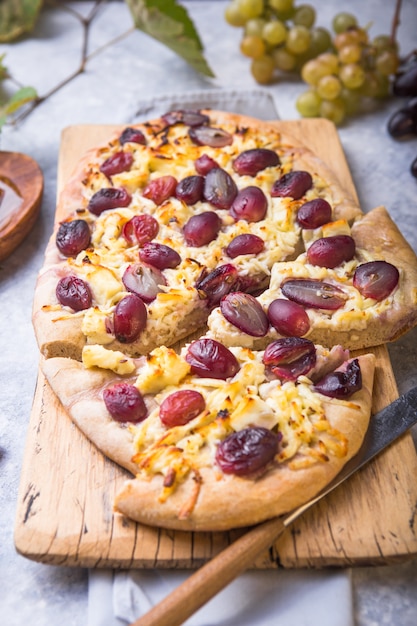 Crosta di pizza con formaggio di capra e uva rossa. Concetto di dieta vegetariana, senza cereali, a basso contenuto di carboidrati, senza glutine