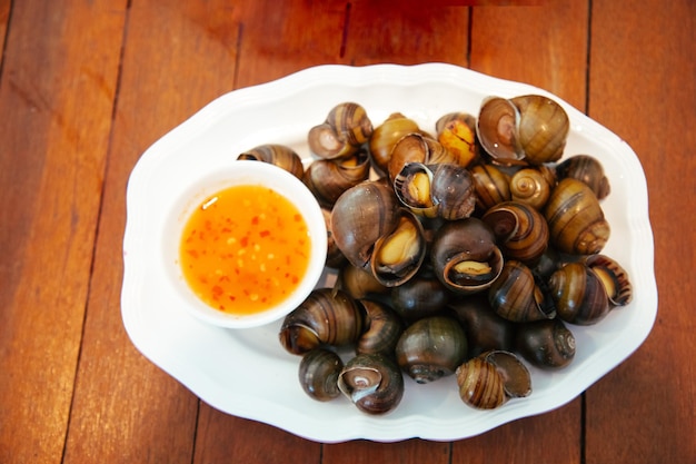 Crostacei lumaca d'acqua dolce nautilus ammonite con salsa di peperoncino piccante Mela golden bollita lumaca di fiume cucinata per cibo asiatico in Thailandia