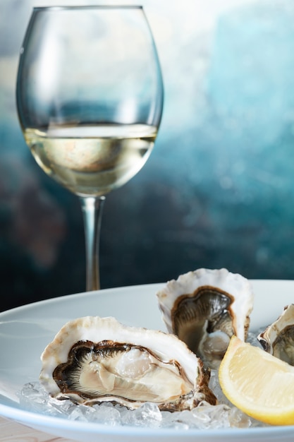 Crostacei ostriche fresche crude con limone in zolla bianca con vino - stile di mare