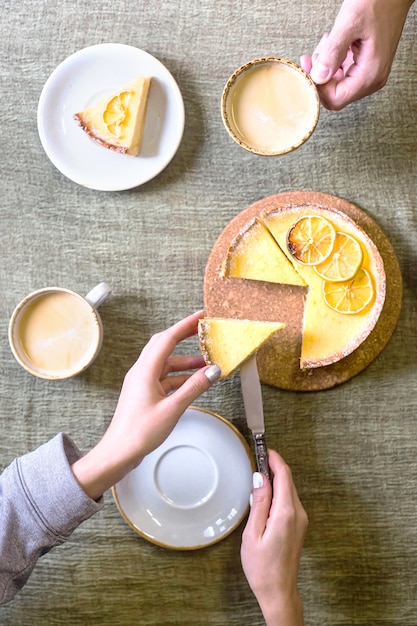 Crostata al limone sul tavolo tra piattini e tazze di caffè.