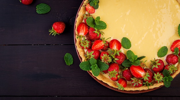 Crostata con fragole e panna montata decorata con foglie di menta