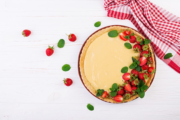 Crostata con fragole e panna montata decorata con foglie di menta