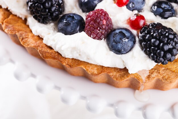 Crostata con frutti di bosco e panna montata.