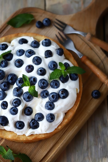 Crostata con mirtilli e crema al burro bianca. Dessert estivo ai frutti di bosco.