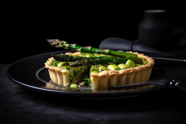 Crostata di asparagi sulla piastra bianca con sfondo nero