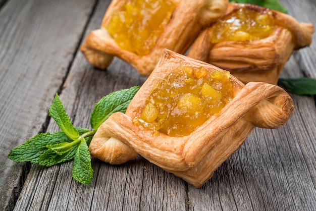 Crostata di frutta fresca con marmellata di bacche e menta su superficie di legno