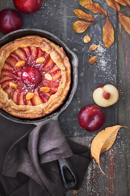 Crostata fatta in casa con fette di prugne cotte in padella di ferro